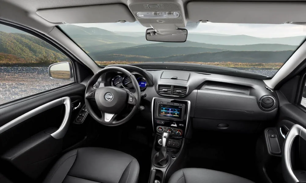 Фото Nissan Terrano — передняя панель. Панель в тёмной отделке — видна компоновка экранов и органов управления Nissan Terrano — передняя панель