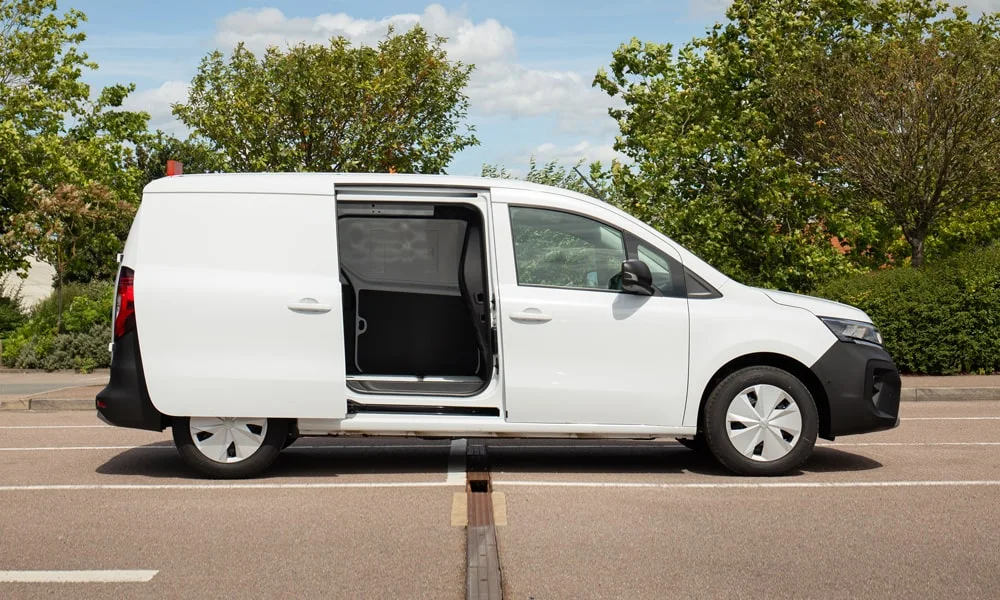 Фото Nissan Townstar — вид сбоку, фото 4. Сбоку читаются линия остекления и характер выштамповок на белом кузове. Длинная база — простор второго ряда; короткие свесы упрощают парковку Nissan Townstar — вид сбоку, фото 4