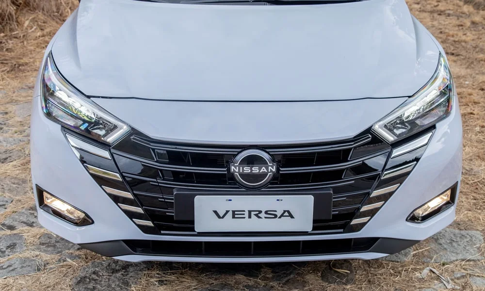 Фото Nissan Versa (2024) — вид спереди, фото 8. Серый кузов, строгая симметрия оптики — базовый ракурс знакомства с дизайном Nissan Versa (2024) — вид спереди, фото 8