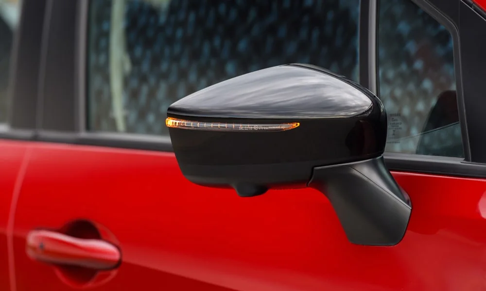 Фото Nissan Versa (2024) — наружное зеркало. Корпус с повторителем поворота; у ряда версий здесь же камера кругового обзора. Обогрев и электроскладывание зеркал управляются с водительской двери Nissan Versa (2024) — наружное зеркало