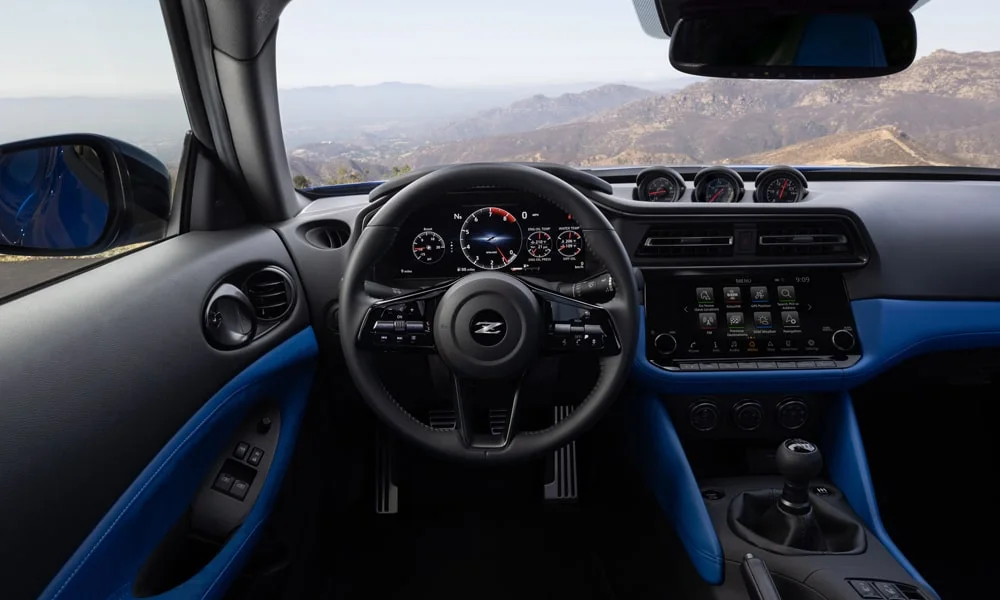 Фото Nissan Z (2024) — передняя панель. Передняя панель в тёмно-синей отделке: расположение экранов и дефлекторов. Мягкие материалы верхнего яруса и вставки задают уровень интерьера Nissan Z (2024) — передняя панель