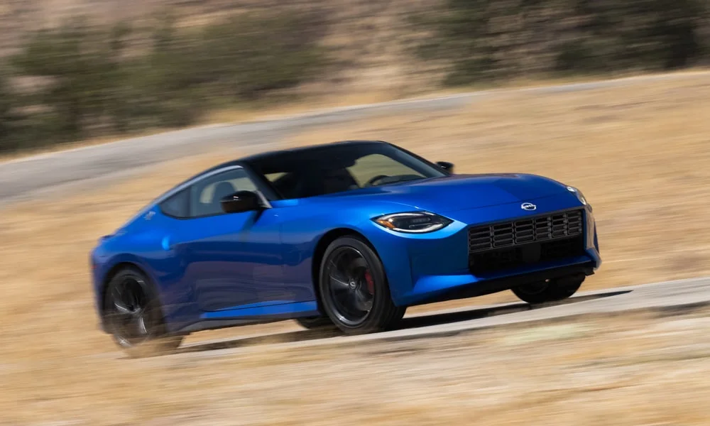 Фото Nissan Z (2024) — вид спереди, фото 11. Кузов в синем цвете: рисунок оптики и решётки задаёт узнаваемое «лицо» модели Nissan Z (2024) — вид спереди, фото 11