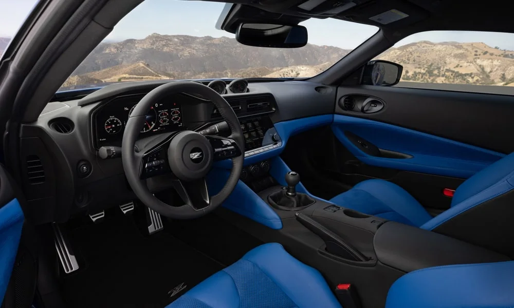 Фото Nissan Z (2024) — интерьер. Интерьер с тёмно-синей отделкой — видно сочетание материалов панели и кресел. Уровень отделки читается по стыкам панелей и мягким поверхностям в зонах касания Nissan Z (2024) — интерьер