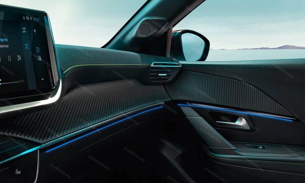 Фото Peugeot 208 — контурная подсветка. Салон вечером: световые акценты по панели и дверям. Цвет и яркость выбираются в настройках; у ряда моделей подсветка реагирует на музыку Peugeot 208 — контурная подсветка