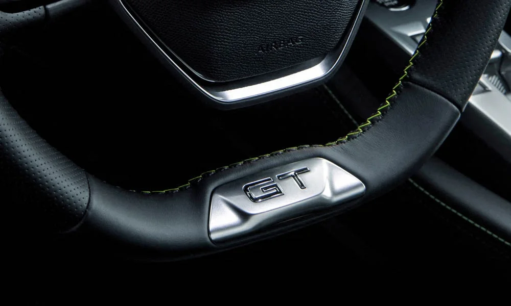 Фото Peugeot 308 — руль, фото 4. Обшивка обода и компоновка спиц крупным планом. Клавиши на спицах управляют медиа, круизом и ассистентами — руки остаются на руле Peugeot 308 — руль, фото 4