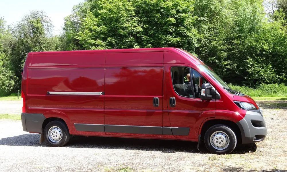 Фото Peugeot Boxer — вид сбоку, фото 2. Красный кузов в профиль — пропорции, высота посадки и дизайн дисков. Хромированные или чёрные молдинги окон отличают комплектации Peugeot Boxer — вид сбоку, фото 2