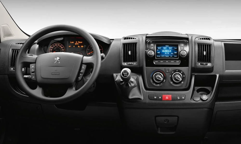 Фото Peugeot Boxer — руль. Обшивка обода и компоновка спиц крупным планом. Правильная посадка: руки на «9 и 3», приборы читаются поверх обода Peugeot Boxer — руль