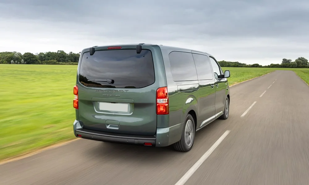 Фото Peugeot Traveller (2024) — вид сзади, фото 5. Корма в зелёном цвете: графика фонарей и пластика пятой двери. Светодиодная полоса или раздельные секции — задняя оптика стала главным украшением кормы Peugeot Traveller (2024) — вид сзади, фото 5