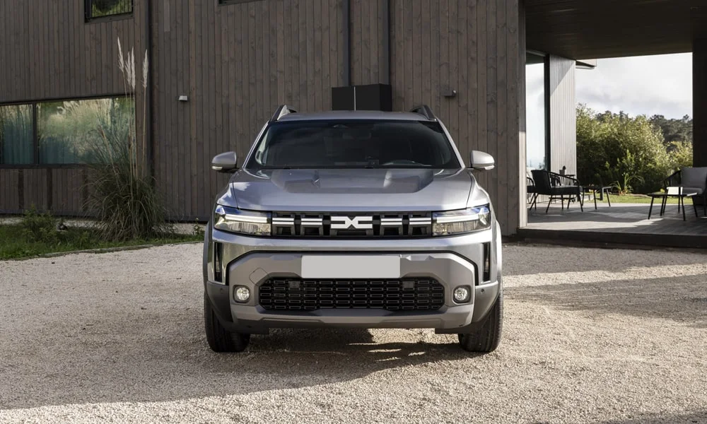 Фото Renault Duster (2024) — вид спереди, фото 5. Передок в серебристом исполнении — крупная светотехника и выразительный бампер. Рисунок ходовых огней — подпись модели, по нему её узнают в потоке Renault Duster (2024) — вид спереди, фото 5