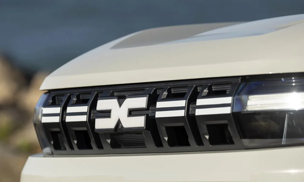 Фото Renault Duster (2024) — решётка радиатора. Рисунок решётки: сетка, ламели или глухая панель у электроверсий. За решёткой у многих комплектаций стоит радар адаптивного круиз-контроля Renault Duster (2024) — решётка радиатора