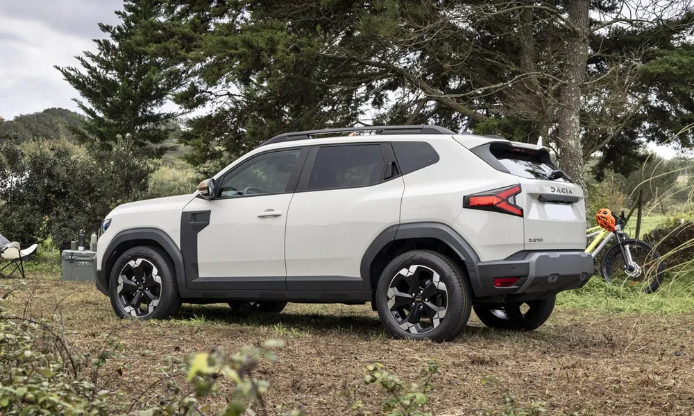 Фото Renault Duster (2024) — вид сзади, фото 3. Линия крыши, стойки и задняя дверь в белом исполнении. Насадки выхлопа или их имитация внизу бампера различают версии Renault Duster (2024) — вид сзади, фото 3