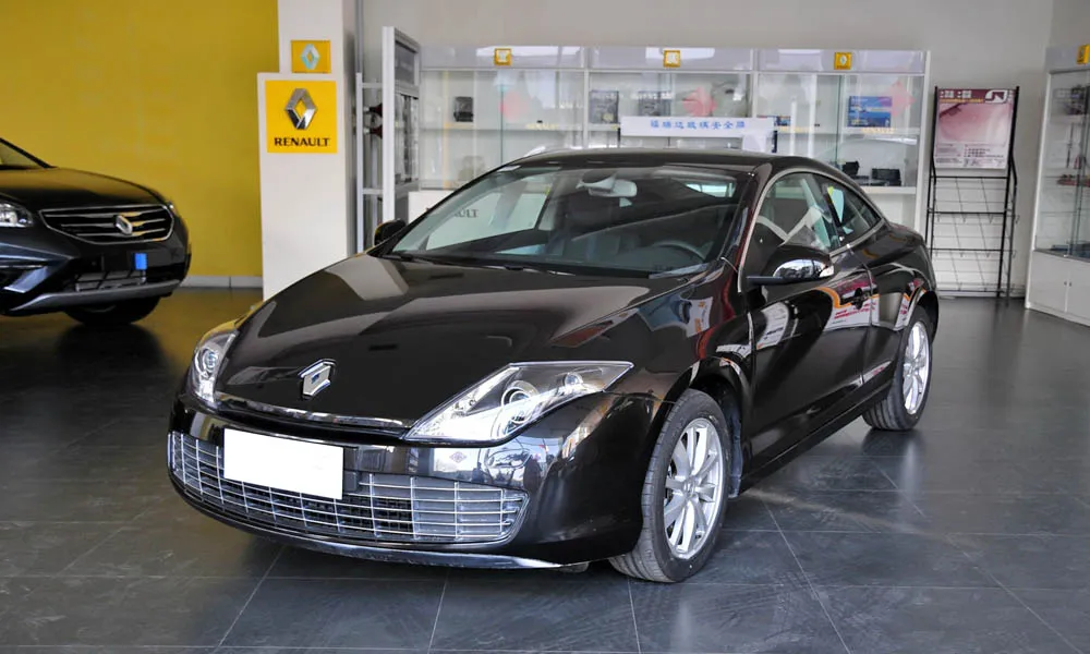 Фото Renault Laguna — вид спереди, фото 6. Кузов в чёрном цвете: рисунок оптики и решётки задаёт узнаваемое «лицо» модели. Рисунок ходовых огней — подпись модели, по нему её узнают в потоке Renault Laguna — вид спереди, фото 6