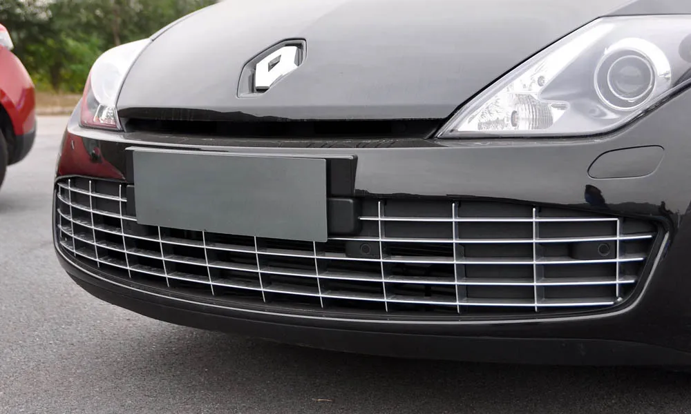 Фото Renault Laguna — решётка радиатора. Рисунок решётки: сетка, ламели или глухая панель у электроверсий. За решёткой у многих комплектаций стоит радар адаптивного круиз-контроля Renault Laguna — решётка радиатора