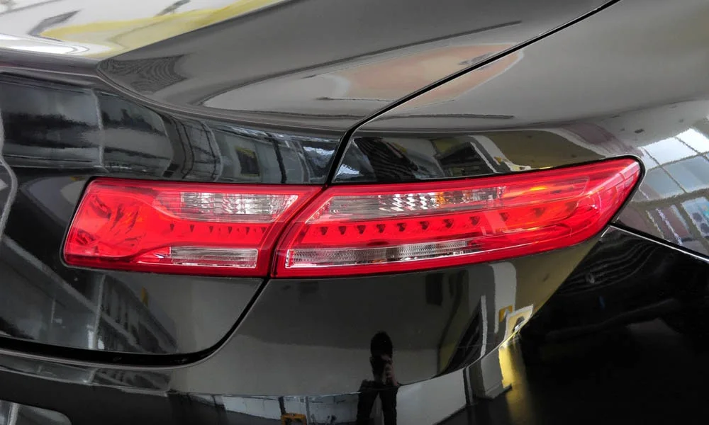Фото Renault Laguna — задние фонари. Рассеиватель фонаря вблизи: компоновка секций габарита, стопа и поворотника. Динамические поворотники с бегущей индикацией встречаются в старших комплектациях Renault Laguna — задние фонари