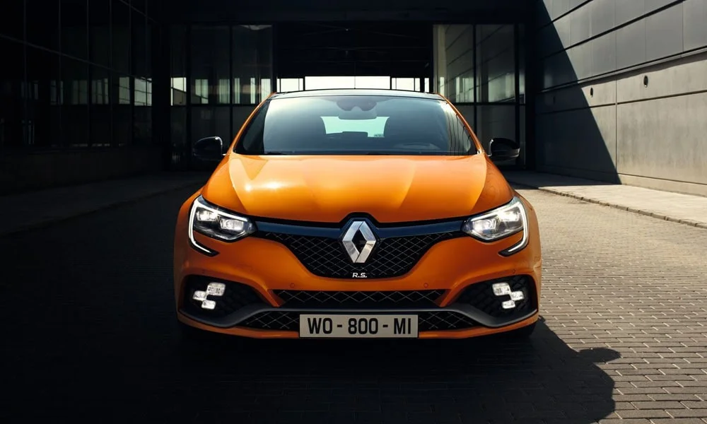 Фото Renault Megane RS — вид спереди, фото 5. Передок в оранжевом исполнении — крупная светотехника и выразительный бампер. Рисунок ходовых огней — подпись модели, по нему её узнают в потоке Renault Megane RS — вид спереди, фото 5
