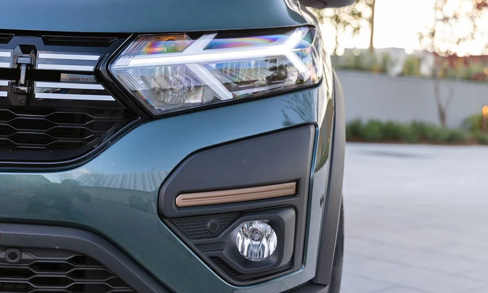 Фото Renault Sandero Stepway (2024) — вид спереди, фото 10. Зелёный кузов, строгая симметрия оптики — базовый ракурс знакомства с дизайном. Рисунок ходовых огней — подпись модели, по нему её узнают в потоке Renault Sandero Stepway (2024) — вид спереди, фото 10