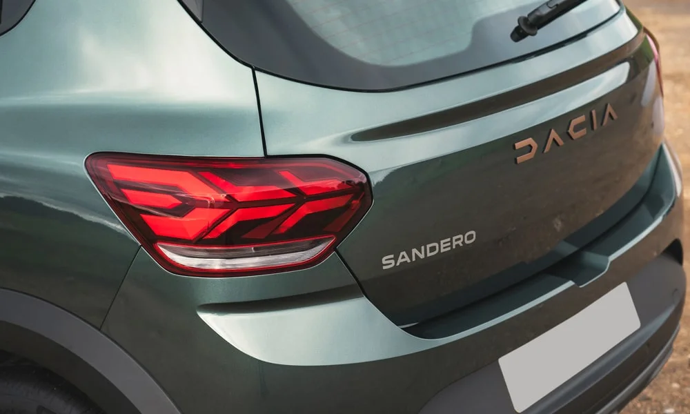 Фото Renault Sandero Stepway (2024) — вид сзади, фото 4. Линия крыши, стойки и задняя дверь в зелёном исполнении. Насадки выхлопа или их имитация внизу бампера различают версии Renault Sandero Stepway (2024) — вид сзади, фото 4
