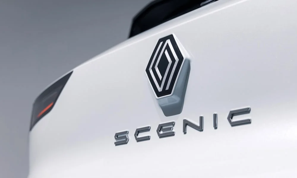 Фото Renault Scenic — эмблема. Логотип марки крупным планом. Шильдик версии на корме помогает отличать комплектации Renault Scenic — эмблема