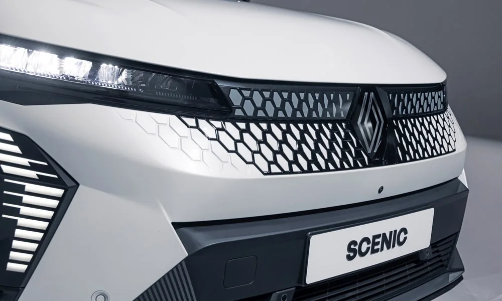 Фото Renault Scenic — решётка радиатора. Рисунок решётки: сетка, ламели или глухая панель у электроверсий. За решёткой у многих комплектаций стоит радар адаптивного круиз-контроля Renault Scenic — решётка радиатора