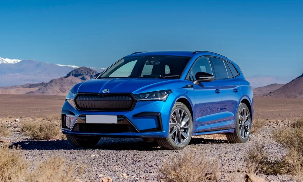 Фото Skoda Enyaq (2024) — вид спереди, фото 9. Кузов в синем цвете: рисунок оптики и решётки задаёт узнаваемое «лицо» модели Skoda Enyaq (2024) — вид спереди, фото 9