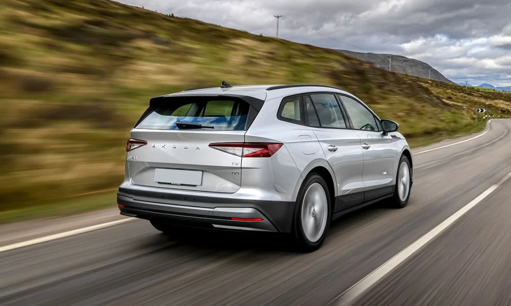 Фото Skoda Enyaq (2024) — вид сзади, фото 3. Линия крыши, стойки и задняя дверь в серебристом исполнении. Светодиодная полоса или раздельные секции — задняя оптика стала главным украшением кормы Skoda Enyaq (2024) — вид сзади, фото 3