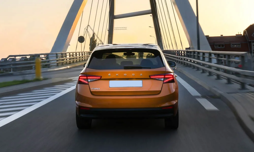 Фото Skoda Fabia — вид сзади, фото 4. Корма в оранжевом цвете: графика фонарей и пластика пятой двери. Насадки выхлопа или их имитация внизу бампера различают версии Skoda Fabia — вид сзади, фото 4