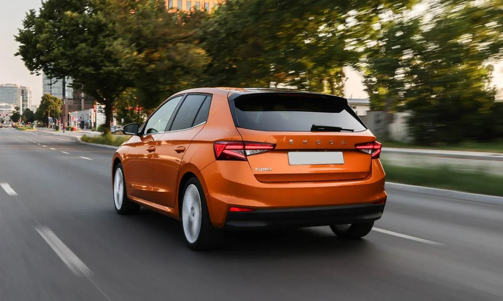 Фото Skoda Fabia — вид сзади, фото 5. Корма в оранжевом цвете: графика фонарей и пластика пятой двери. Насадки выхлопа или их имитация внизу бампера различают версии Skoda Fabia — вид сзади, фото 5