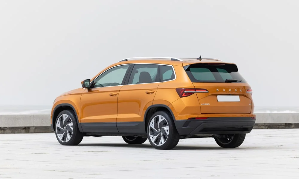 Фото Skoda Karoq (2024) — вид сзади, фото 3. Корма в оранжевом цвете: графика фонарей и пластика пятой двери. Светодиодная полоса или раздельные секции — задняя оптика стала главным украшением кормы Skoda Karoq (2024) — вид сзади, фото 3