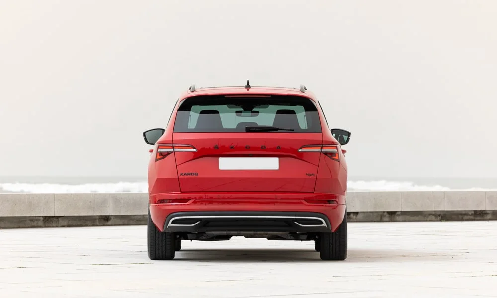 Фото Skoda Karoq (2024) — вид сзади, фото 7. Красный кузов сзади — фонари и бампер определяют ночной образ модели Skoda Karoq (2024) — вид сзади, фото 7