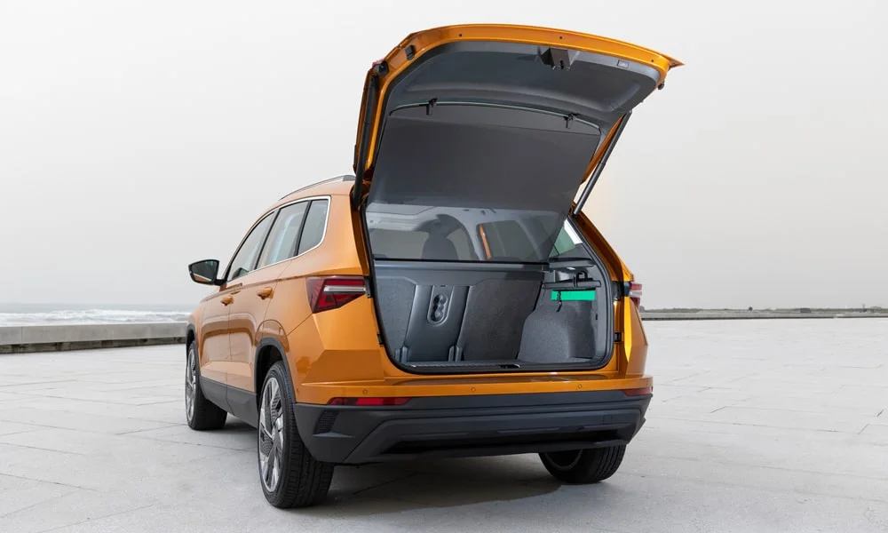 Фото Skoda Karoq (2024) — багажник. Грузовой отсек с открытой дверью: погрузочная высота и ширина проёма. Электропривод двери с датчиком под бампером — руки заняты, багажник открыт Skoda Karoq (2024) — багажник