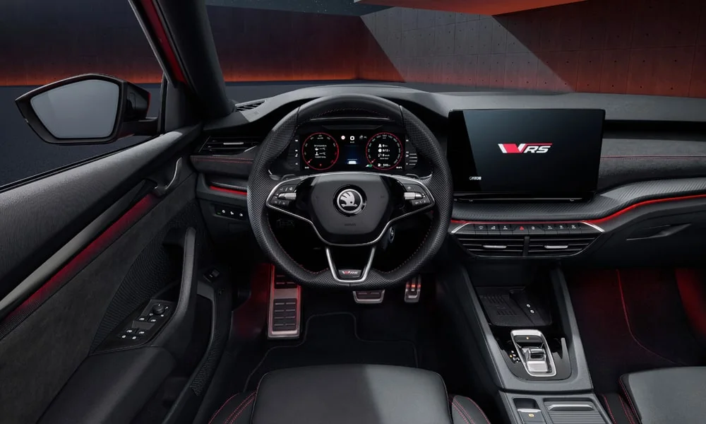 Фото Skoda Octavia Combi RS (2024) — передняя панель. Панель в красно-чёрной отделке — видна компоновка экранов и органов управления. Минимум физических кнопок — ставка на экранное управление Skoda Octavia Combi RS (2024) — передняя панель