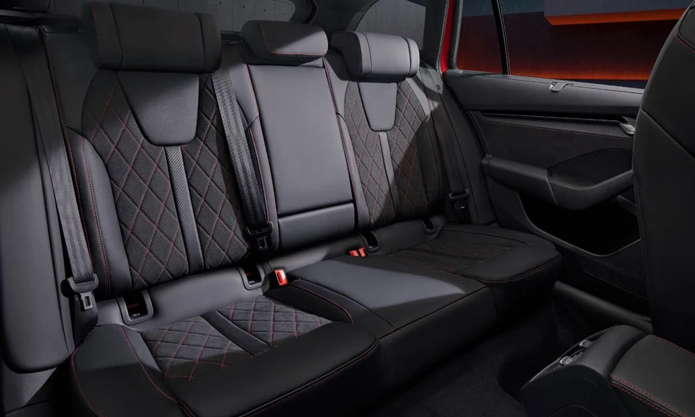 Фото Skoda Octavia Combi RS (2024) — задние сиденья. Посадка второго ряда: подголовники и подлокотник. Спинки складываются под длинные грузы у большинства версий Skoda Octavia Combi RS (2024) — задние сиденья