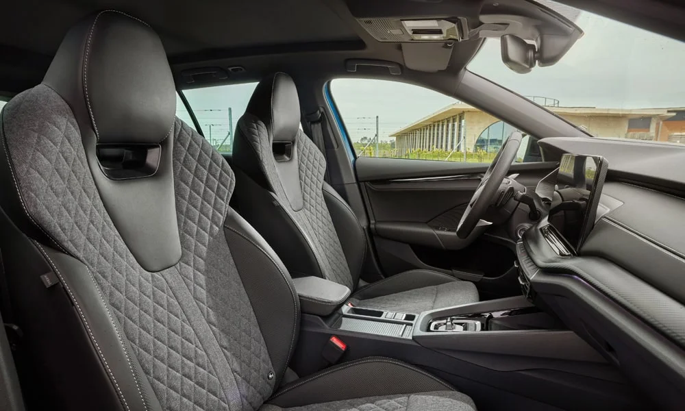 Фото Skoda Octavia Combi (2024) — передние сиденья. Водительское и пассажирское кресла: обивка из алькантаре, профиль с боковой поддержкой. Регулировки с памятью возвращают кресло под водителя одним нажатием — у версий с электроприводом Skoda Octavia Combi (2024) — передние сиденья