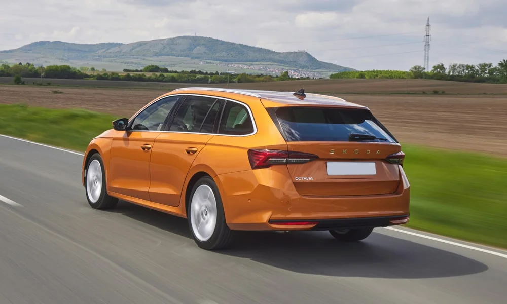 Фото Skoda Octavia Combi (2024) — вид сзади, фото 4. Оранжевый кузов сзади — фонари и бампер определяют ночной образ модели. Светодиодная полоса или раздельные секции — задняя оптика стала главным украшением кормы Skoda Octavia Combi (2024) — вид сзади, фото 4