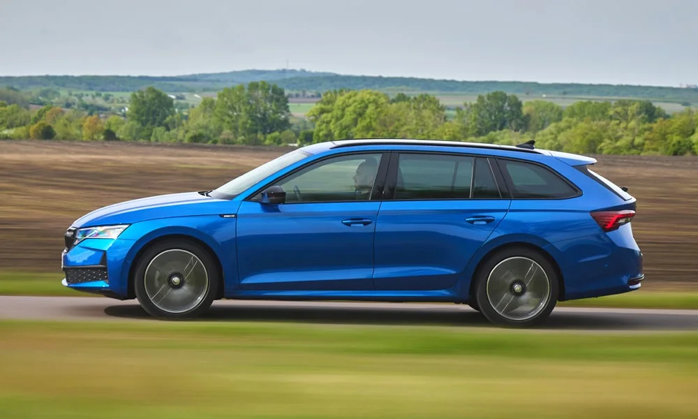 Фото Skoda Octavia Combi (2024) — вид сбоку, фото 6. Сбоку читаются линия остекления и характер выштамповок на синем кузове Skoda Octavia Combi (2024) — вид сбоку, фото 6