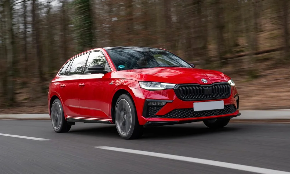 Фото Skoda Scala (2024) — вид спереди, фото 8. Кузов в красном цвете: рисунок оптики и решётки задаёт узнаваемое «лицо» модели. Дневные ходовые огни включаются автоматически с запуском Skoda Scala (2024) — вид спереди, фото 8