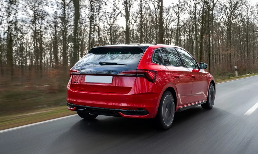 Фото Skoda Scala (2024) — вид сзади, фото 3. Линия крыши, стойки и задняя дверь в красном исполнении. Насадки выхлопа или их имитация внизу бампера различают версии Skoda Scala (2024) — вид сзади, фото 3