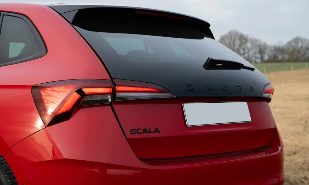 Фото Skoda Scala (2024) — вид сзади, фото 6. Корма в красном цвете: графика фонарей и пластика пятой двери. Насадки выхлопа или их имитация внизу бампера различают версии Skoda Scala (2024) — вид сзади, фото 6