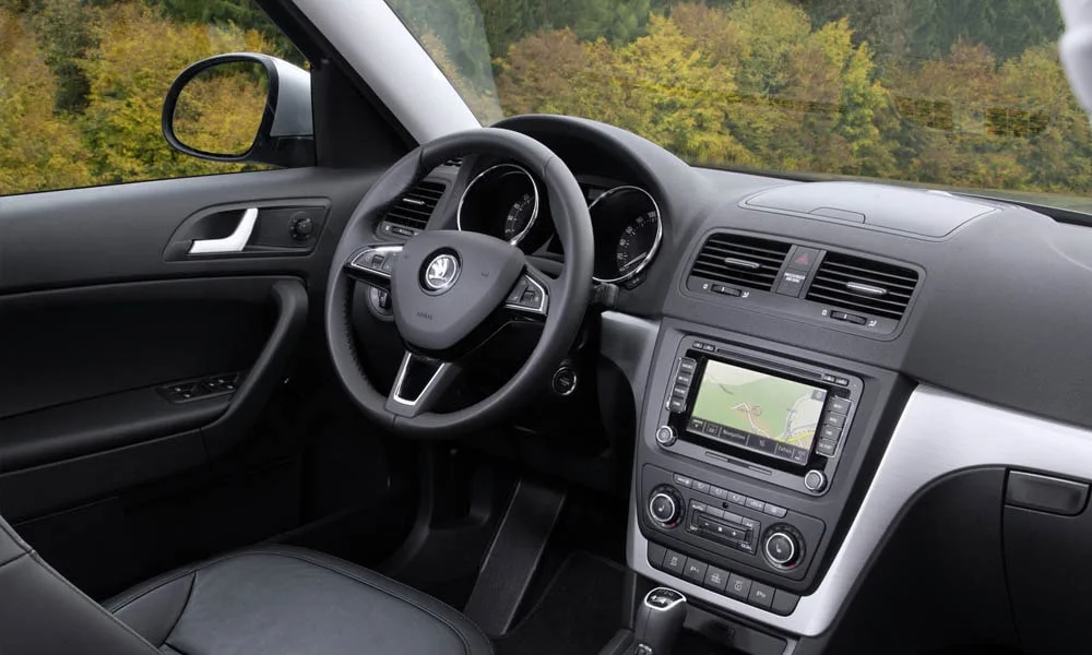 Фото Skoda Yeti — передняя панель. Передняя панель в тёмной отделке: расположение экранов и дефлекторов. Минимум физических кнопок — ставка на экранное управление Skoda Yeti — передняя панель