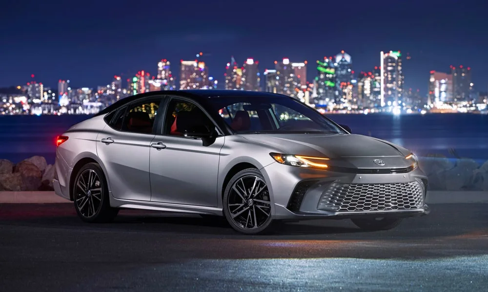 Фото Toyota Camry (2024) — вид спереди, фото 4. Кузов в серебристом цвете: рисунок оптики и решётки задаёт узнаваемое «лицо» модели Toyota Camry (2024) — вид спереди, фото 4