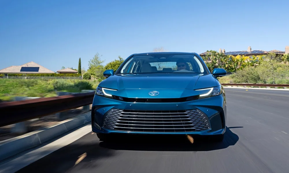 Фото Toyota Camry (2024) — вид спереди, фото 7. Анфас: пропорции капота, посадка кузова и графика ходовых огней. Рисунок ходовых огней — подпись модели, по нему её узнают в потоке Toyota Camry (2024) — вид спереди, фото 7