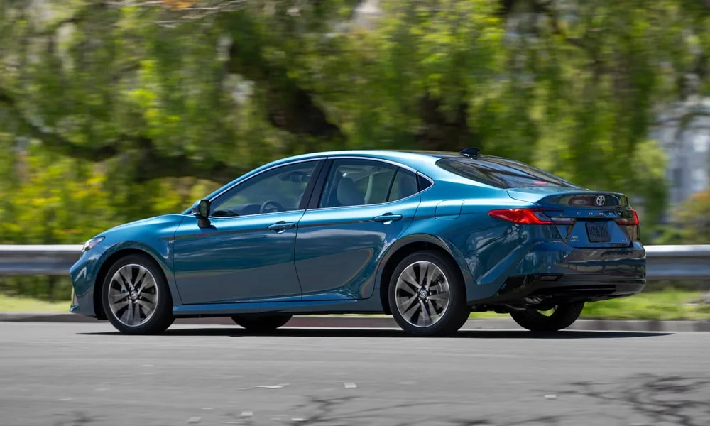 Фото Toyota Camry (2024) — вид сзади, фото 7. Корма в синем цвете: графика фонарей и пластика пятой двери. Светодиодная полоса или раздельные секции — задняя оптика стала главным украшением кормы Toyota Camry (2024) — вид сзади, фото 7
