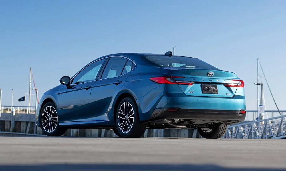 Фото Toyota Camry (2024) — вид сзади, фото 8. Линия крыши, стойки и задняя дверь в синем исполнении Toyota Camry (2024) — вид сзади, фото 8