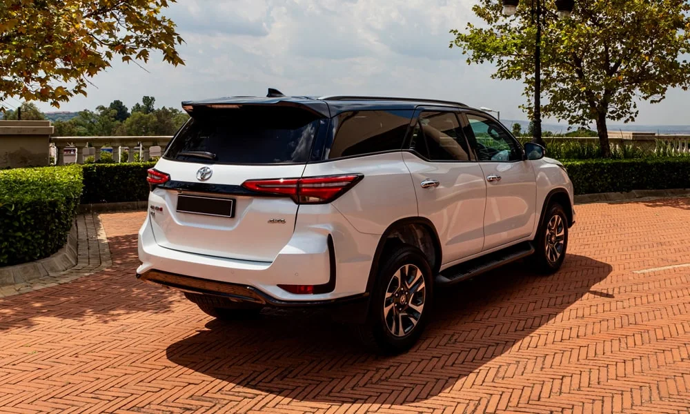 Фото Toyota Fortuner (2024) — вид сзади, фото 3. Корма в белом цвете: графика фонарей и пластика пятой двери. Насадки выхлопа или их имитация внизу бампера различают версии Toyota Fortuner (2024) — вид сзади, фото 3