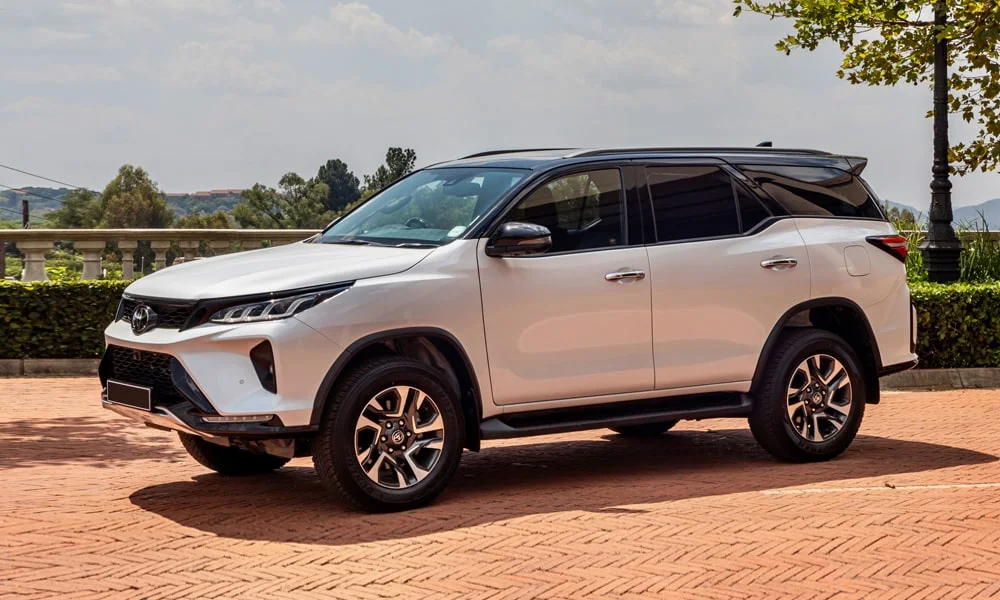 Фото Toyota Fortuner (2024) — вид сбоку, фото 3. Профиль в белом цвете: соотношение колёсной базы и свесов. Длинная база — простор второго ряда; короткие свесы упрощают парковку Toyota Fortuner (2024) — вид сбоку, фото 3