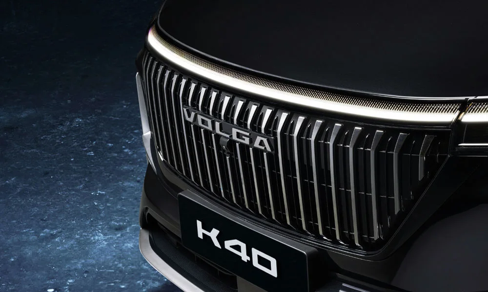 Фото Volga K40 (2024) — решётка радиатора. Фирменный рисунок облицовки — визитная карточка марки. Активные жалюзи за решёткой закрываются на трассе ради аэродинамики — есть у ряда моделей Volga K40 (2024) — решётка радиатора