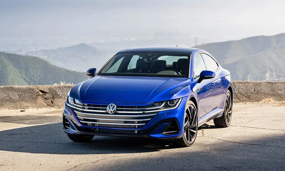 Фото Volkswagen Arteon (2024) — вид спереди, фото 10. Синий кузов, строгая симметрия оптики — базовый ракурс знакомства с дизайном Volkswagen Arteon (2024) — вид спереди, фото 10