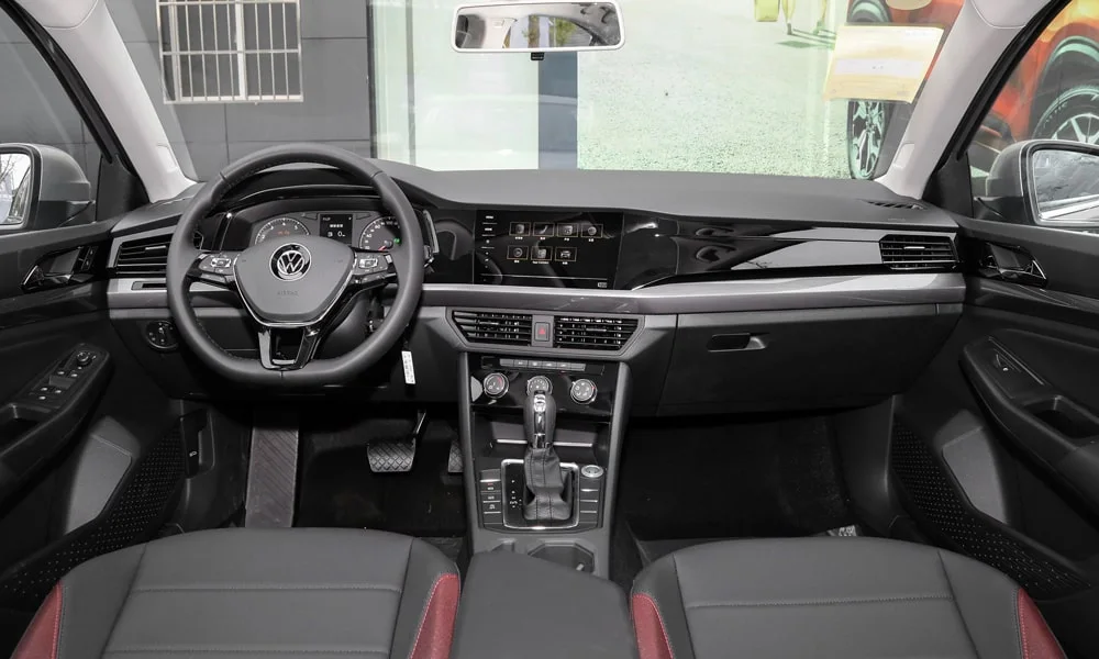 Фото Volkswagen Bora — передняя панель. Передняя панель в красно-чёрной отделке: расположение экранов и дефлекторов. Минимум физических кнопок — ставка на экранное управление Volkswagen Bora — передняя панель