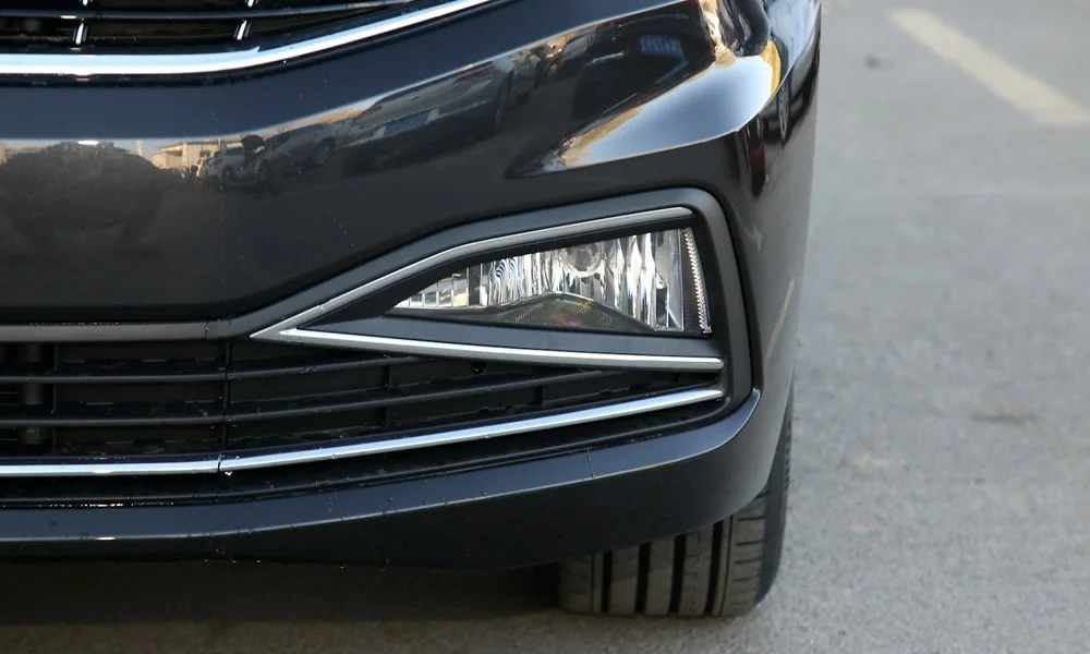 Фото Volkswagen Bora — вид спереди, фото 8. Чёрный кузов, строгая симметрия оптики — базовый ракурс знакомства с дизайном. Рисунок ходовых огней — подпись модели, по нему её узнают в потоке Volkswagen Bora — вид спереди, фото 8