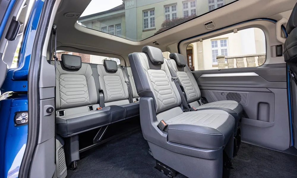 Фото Volkswagen Caravelle (2024) — задние сиденья, фото 2. Посадка второго ряда: подголовники и подлокотник Volkswagen Caravelle (2024) — задние сиденья, фото 2